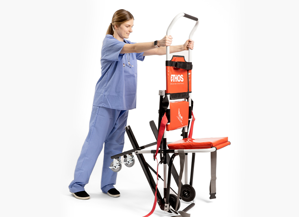 Female clinician unfolding red chair with wheels.